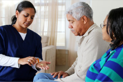 caregiver giving medicines to patient