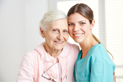 elder woman with her caregiver smiling